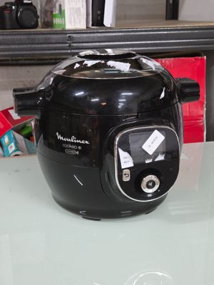 une friteuse à air chaud noire et argentée posée sur une table