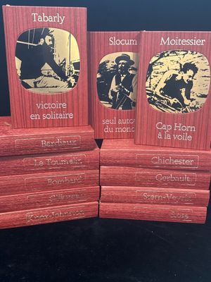 trois livres rouges empilés les uns sur les autres sur une table