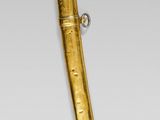 gold plated dagger with a curved blade and a metal handle