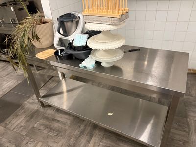 une table en acier inoxydable sur laquelle est posé un gâteau