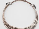 un gros plan d'un collier en argent sur fond blanc