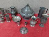 un assortiment d'objets en étain sur une table recouverte d'une nappe rouge