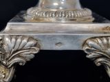 a silver vase that is sitting on a table