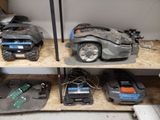 two lawn mowers sitting on a shelf in a garage