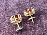 two pairs of gold colored earrings on a purple surface