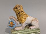 une figurine représentant un lion tenant un poisson dans la gueule