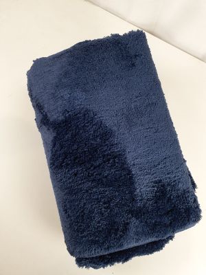 une serviette bleu marine pliée sur une surface blanche