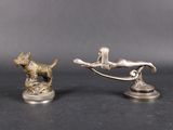 paire de figurines en argent représentant un chien et un homme sur une balançoire