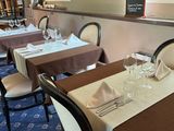 a dining room with tables and chairs and a menu board on the wall