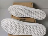 a pair of white sneakers sitting on top of a box