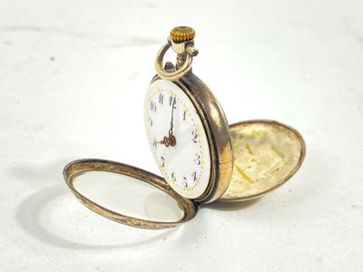a pocket watch sitting on a table with a magnifying lens