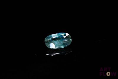 a close up of a blue sapphire stone on a black surface