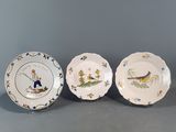 three plates with birds and flowers on them sitting on a table