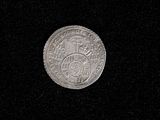 a close up of a silver coin on a black surface