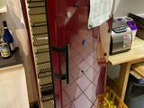 a red refrigerator that is in a kitchen with a microwave on top of it