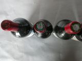 three bottles of wine are lined up on a white surface