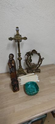 a small table with a candle and a cross on it