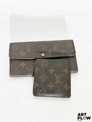 deux portefeuilles Louis Vuitton posés l'un à côté de l'autre sur une surface blanche