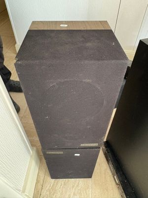 a black speaker sitting on top of a wooden table