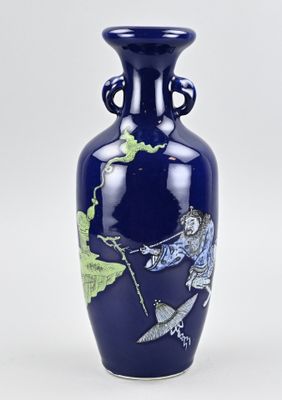 un vase bleu orné d'un dragon, posé sur une table