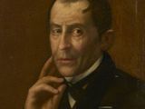 portrait d'un homme en costume noir et nœud papillon, la main posée sur le menton