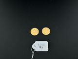 a pair of gold coins with a price tag on a black background