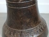 a bronze bell that is sitting on the floor