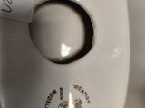 a close up of a white vase with a label on it