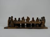 figurine en bois sculpté représentant un groupe de personnes assises à une table