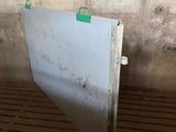 a metal door with a green handle in a dirty room