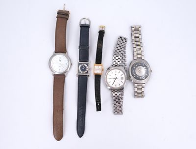 quatre montres différentes sont alignées sur une surface blanche