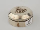 an image of a silver box on a white surface with a gold emblem on it