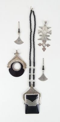 un assortiment de bijoux argentés et noirs sur un fond blanc