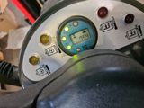 a close up of a steering wheel with a clock on it