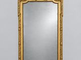un miroir à cadre doré accroché au mur d'une pièce