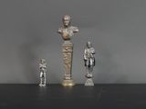 trois figurines en argent représentant des hommes et un buste d'homme sur un socle