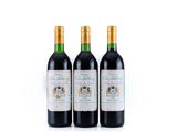 trois bouteilles de vin rouge posées l'une à côté de l'autre sur une surface blanche