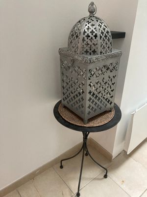 une cage à oiseaux posée sur une petite table dans un coin de la pièce