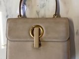 sac à main en cuir beige avec des finitions et une poignée dorées