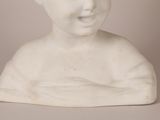 a white statue of a boy with a smile on his face
