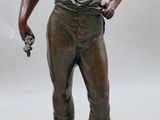 bronze statue of a boy with a gun on a base