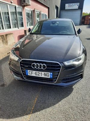 Une Audi noire est garée devant un immeuble