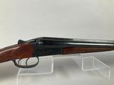 a shotgun with a wooden barrel and a black handle