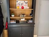 a bookcase with a coat rack and a chair in the corner