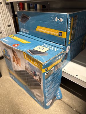 deux cartons contenant des téléviseurs empilés l'un sur l'autre dans un magasin