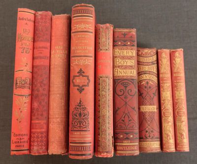 several old books are lined up in a row on a table