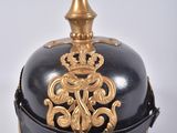 une cloche noire et dorée surmontée d'une couronne dorée