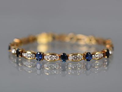 un bracelet en or jaune serti de diamants bleus et blancs