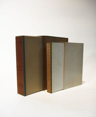three books are stacked on top of each other on a white surface