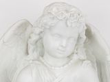 a white statue of an angel holding a flower